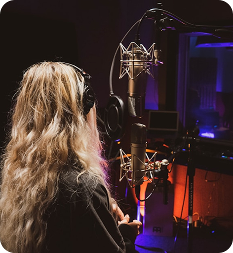 Professional voice-over artist recording high-quality audio in a soundproof studio for multilingual media production.
